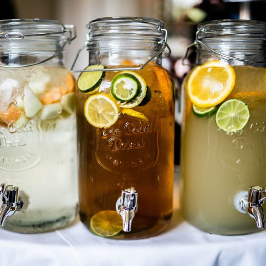 Firefly Peach Punch: 3 glass jars with spigots filled with punch and fruit slices