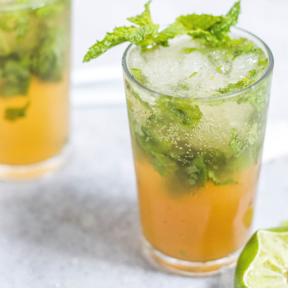 Glass with tea, ice, and mint leaves. Lime slice