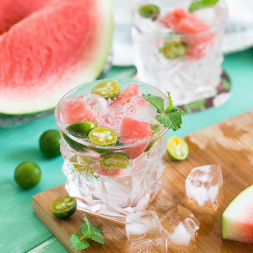 Glass with ice cubes, watermelon, and limes