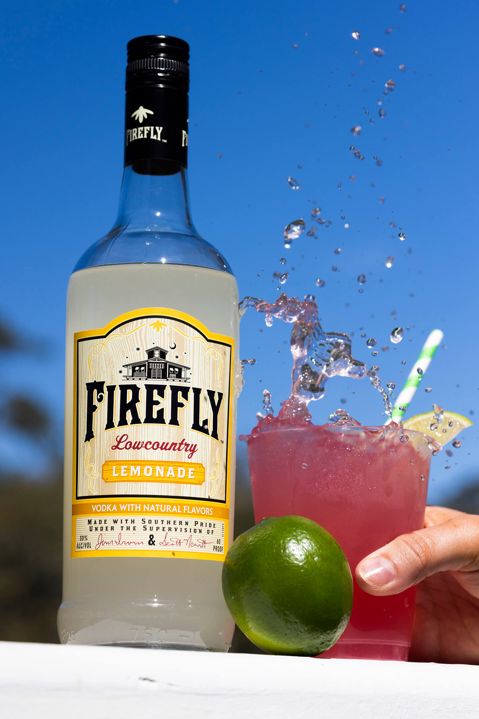 Firefly Lemonade Vodka Bottle, Lime, hand holding beverage in a glass